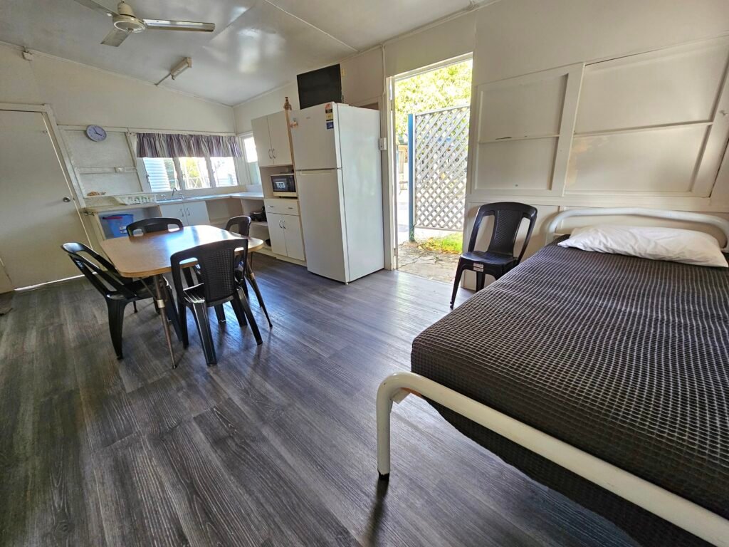 Living Area of sunset beach bungalows showing fridge and extra beds and dining table