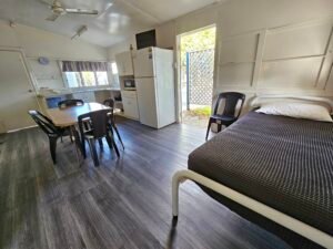 Living Area of sunset beach bungalows showing fridge and extra beds and dining table